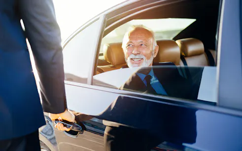 Private transfer service at Tokyo airport with driver opening car door.