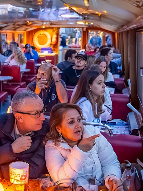 Evening canal cruise in Amsterdam with passengers enjoying the view.