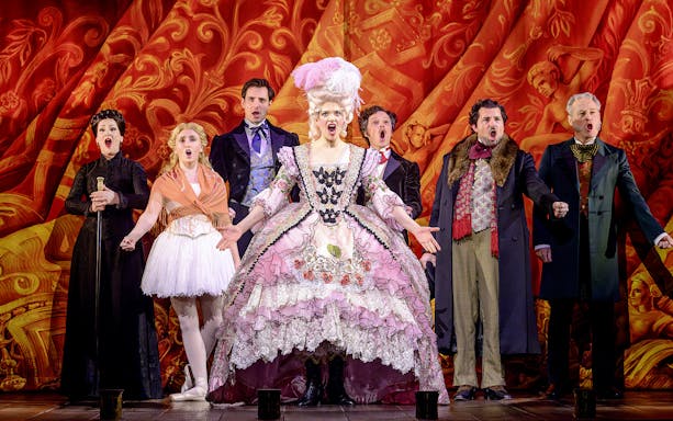 Cast performing in The Phantom of the Opera musical in Vienna, vibrant costumes and dramatic backdrop.