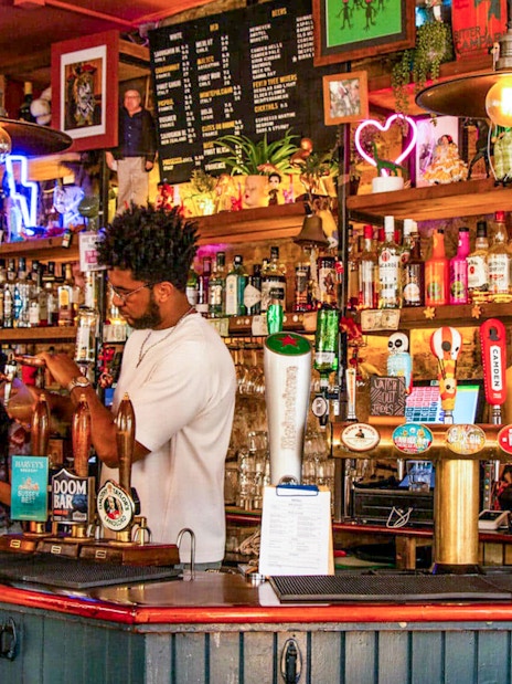 Bar scene in Soho, London with bartender serving drinks during the Twilight Soho Food & Drinks Tour.