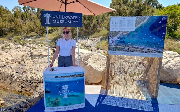 Underwater Museum Croatia information booth with map display at beach resort.
