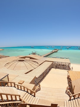 Deck and pier at Orange Bay Island, Hurghada with turquoise sea and boats in the distance.