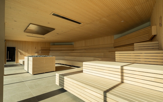 Spacious sauna room with wooden benches at Milan Wellness Spa.