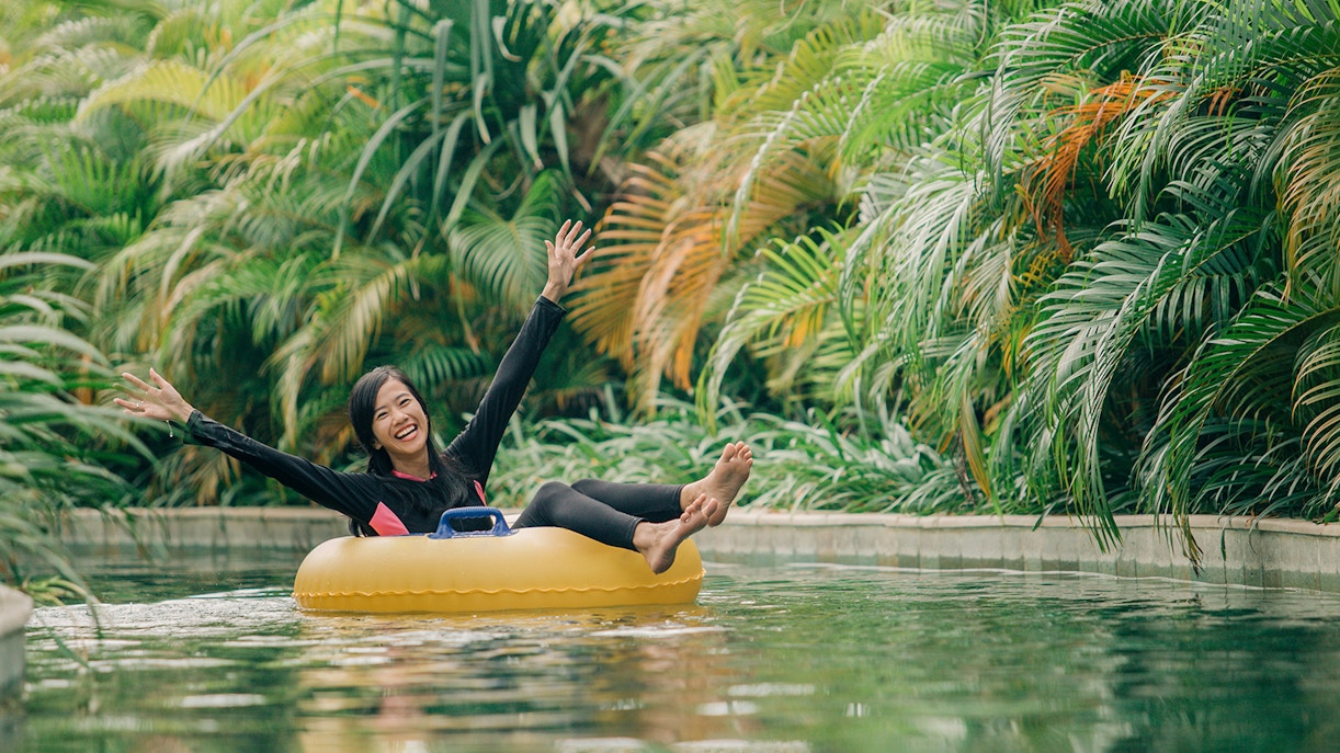 Girl floating in a ring on lazy river at Waterbom Bali, Indonesia.