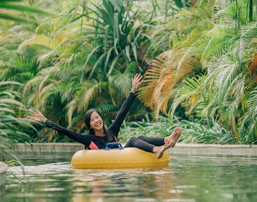 Girl floating in a ring on lazy river at Waterbom Bali, Indonesia.