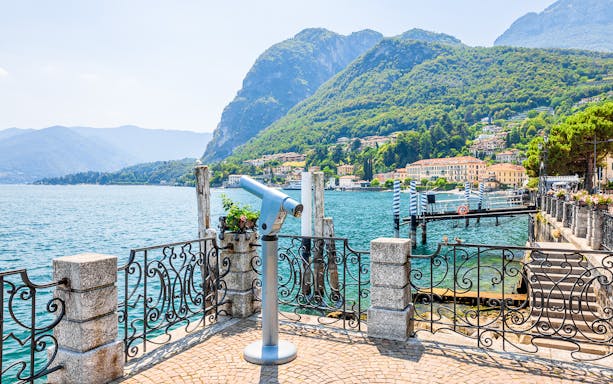 Scenic view of Lake Como with mountains and waterfront promenade in Italy.