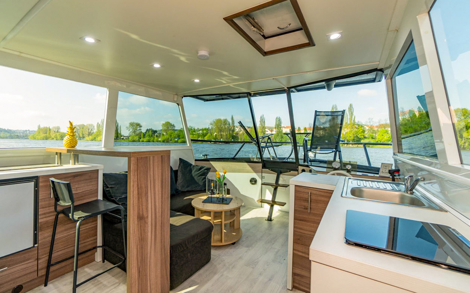 Interior of Prague VIP YachtBoat ONE with seating area and river view.