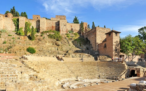 Roman Theater and Alcazaba in Málaga, Spain, with ancient stone seating and fortress walls.
