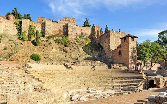 Roman Theater and Alcazaba in Málaga, Spain, with ancient stone seating and fortress walls.