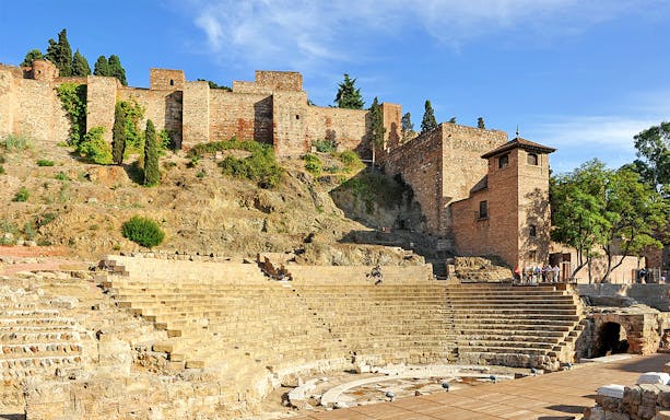 Roman Theater and Alcazaba in Málaga, Spain, with ancient stone seating and fortress walls.