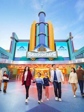 Families walking in front of Genting SkyWorlds Theme Park entrance.