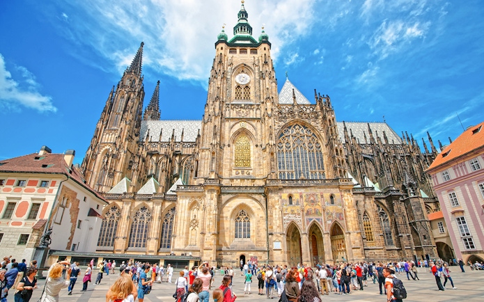 St Vitus Cathedral exterior at Prague Castle with tourists in the foreground.