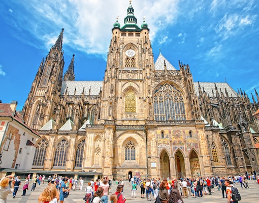 St Vitus Cathedral exterior at Prague Castle with tourists in the foreground.