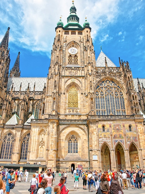 St Vitus Cathedral exterior at Prague Castle with tourists in the foreground.