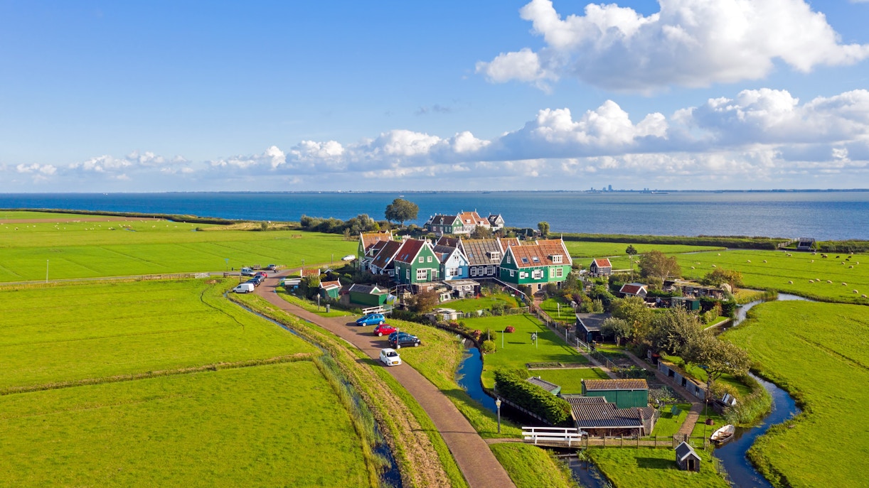 Aerial view of Marken village with green fields and IJsselmeer in the Netherlands.