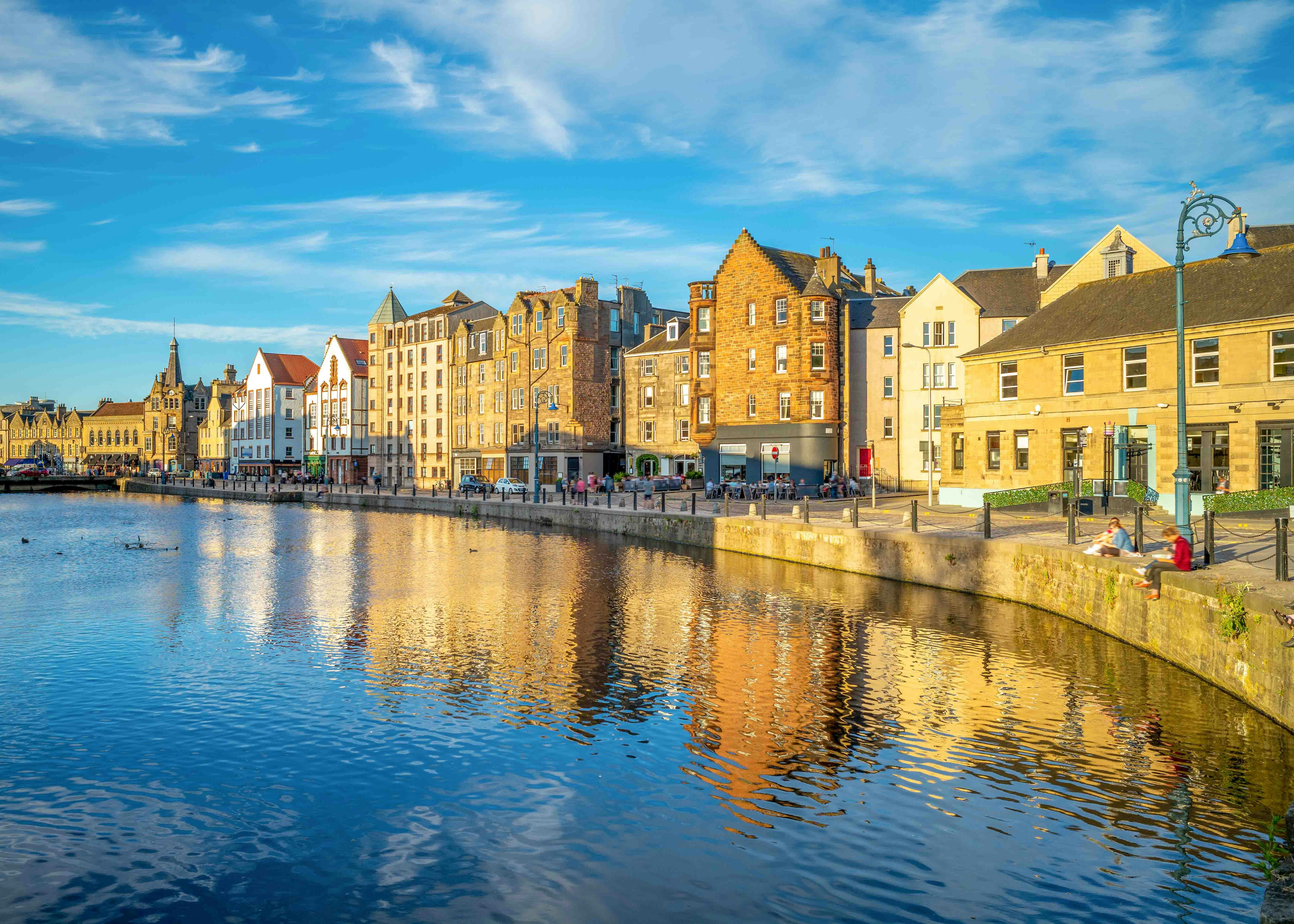 Waterfront buildings along the Shore in Leith, Edinburgh, reflecting in the Water of Leith.