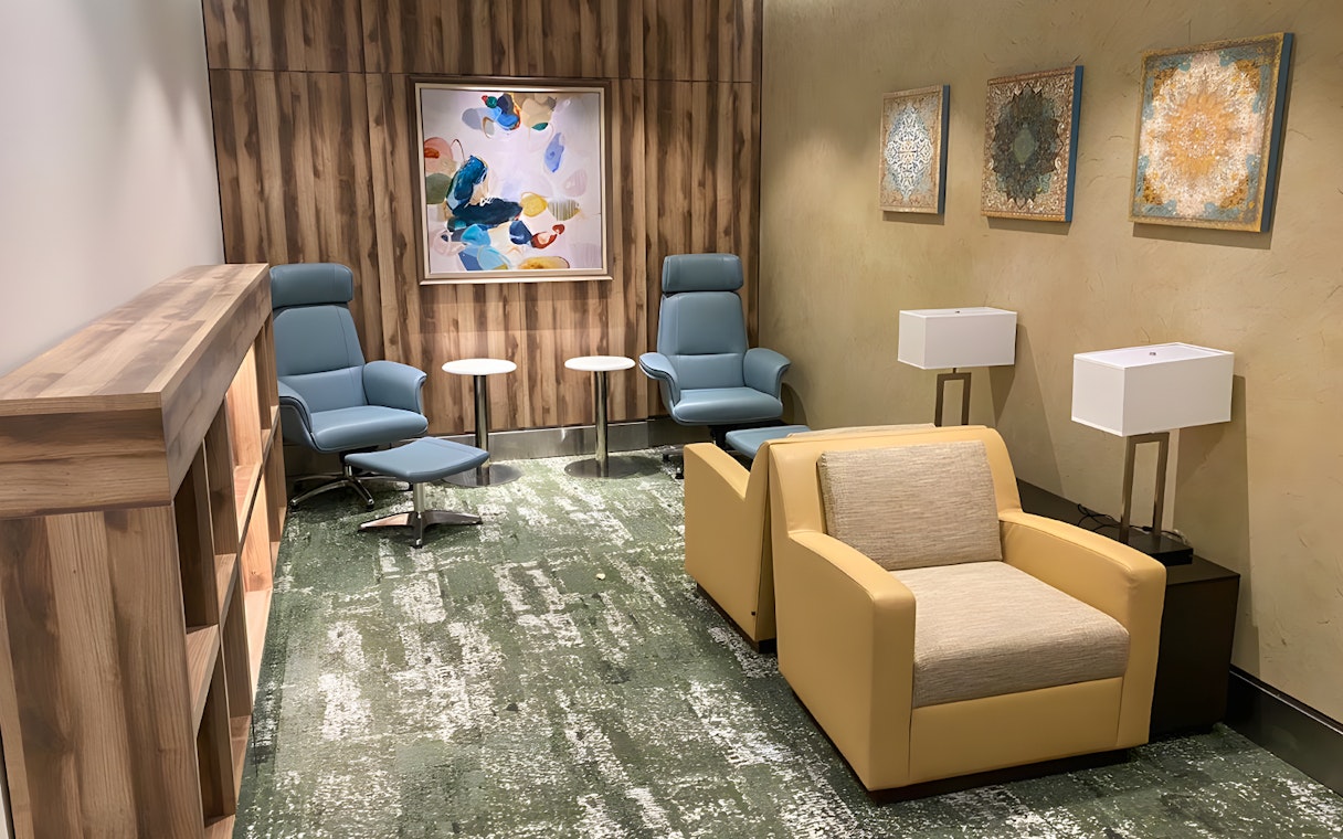 Premium lounge seating area at Jeddah Airport with modern chairs and artwork.