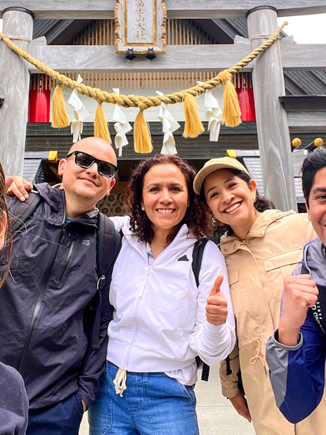 Group of tourists smiling in front of a shrine on the Fantastic Fuji & Hakone 1-Day Bus Tour.