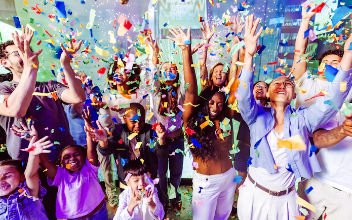 Group celebrating with confetti at One Times Square, New York City.