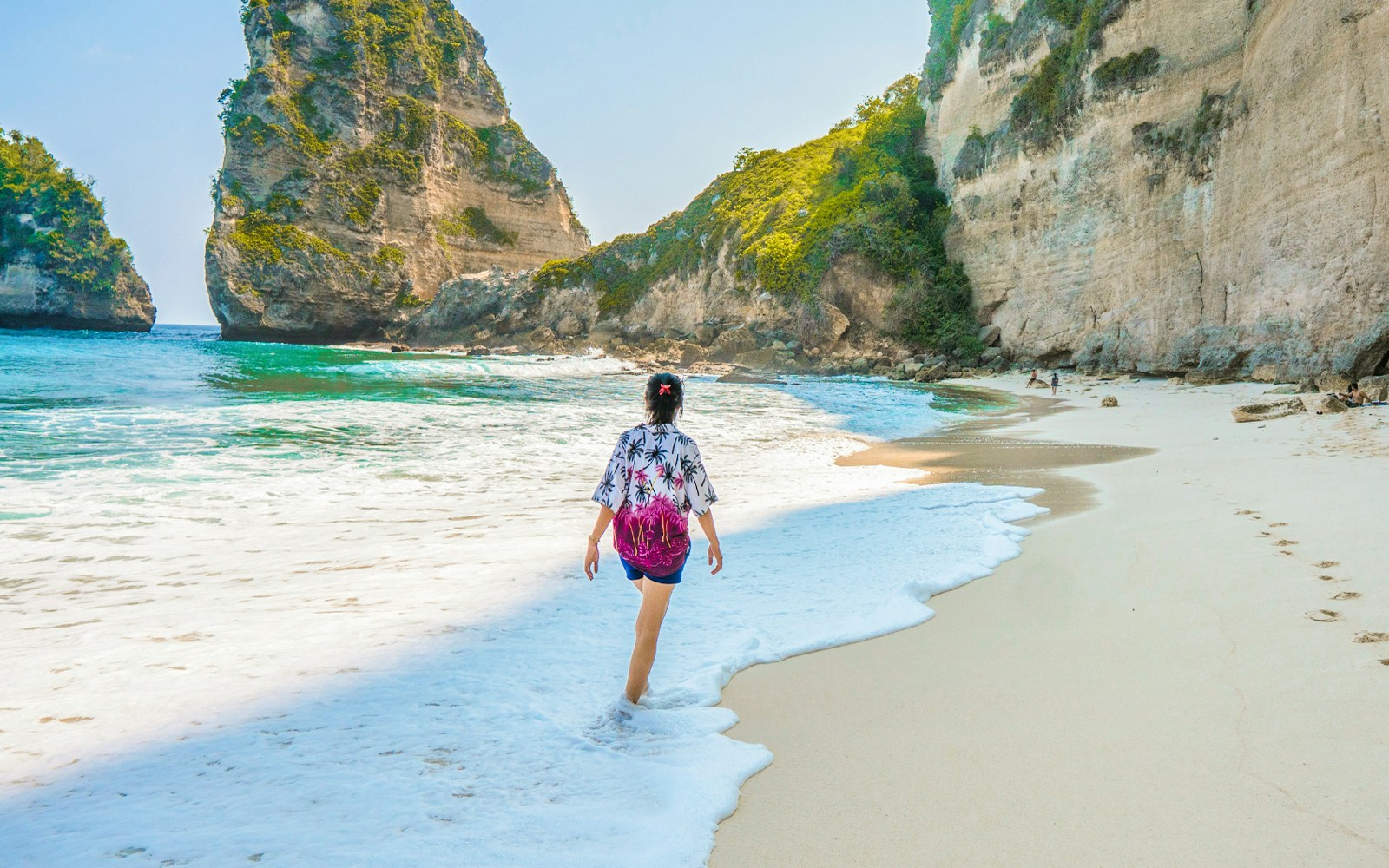 Diamond Beach Nusa Penida Island tour showcasing tourists enjoying the pristine beach and turquoise waters, Bali
