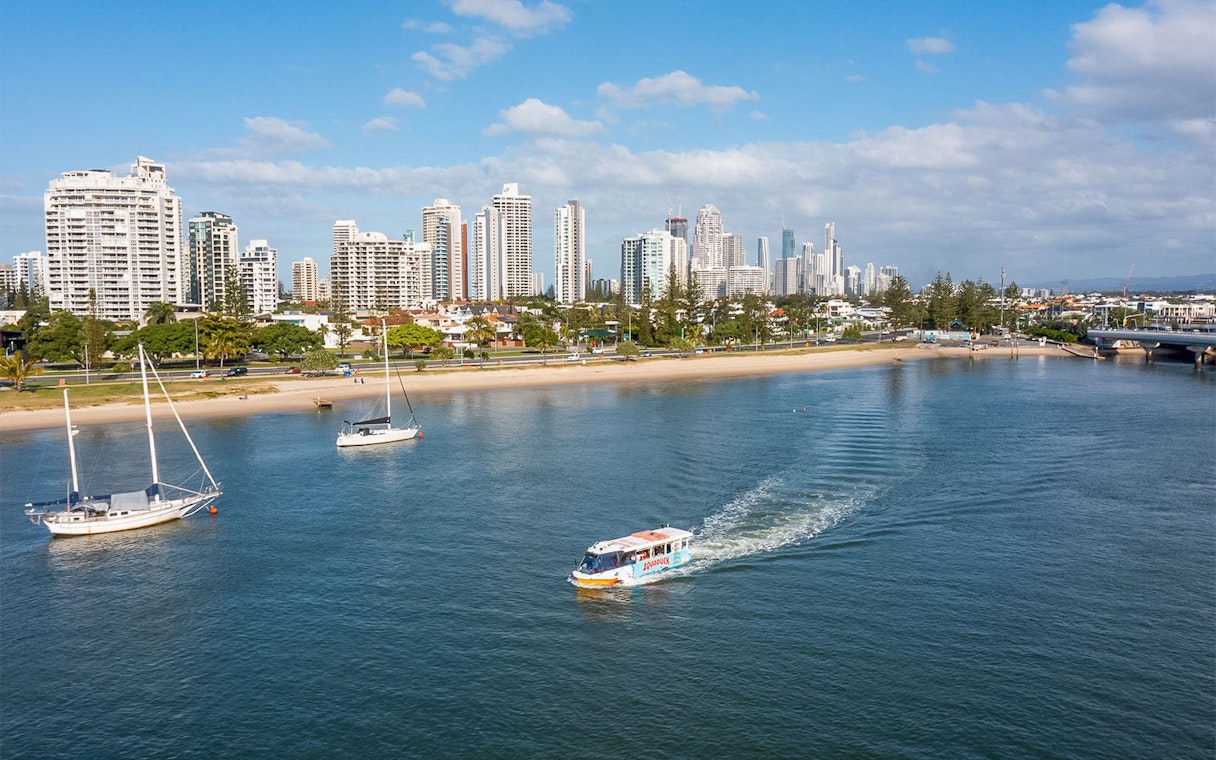 Aquaduck tour boat cruising along Sunshine Coast with city skyline in the background.