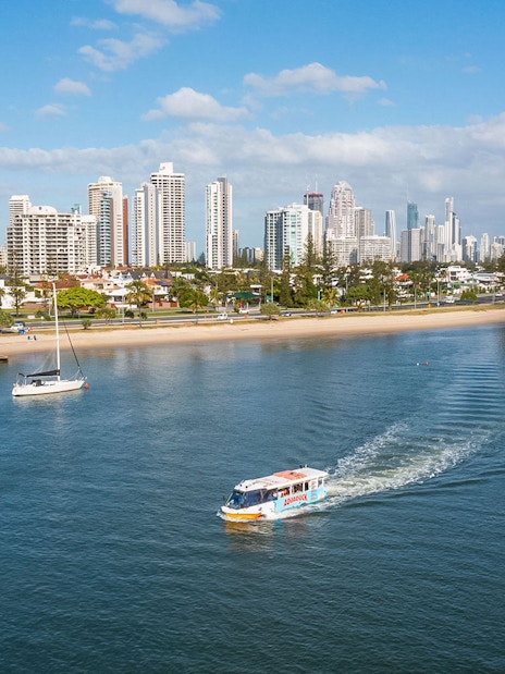 Aquaduck tour boat cruising along Sunshine Coast with city skyline in the background.