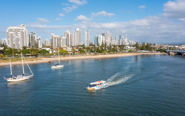 Aquaduck tour boat cruising along Sunshine Coast with city skyline in the background.