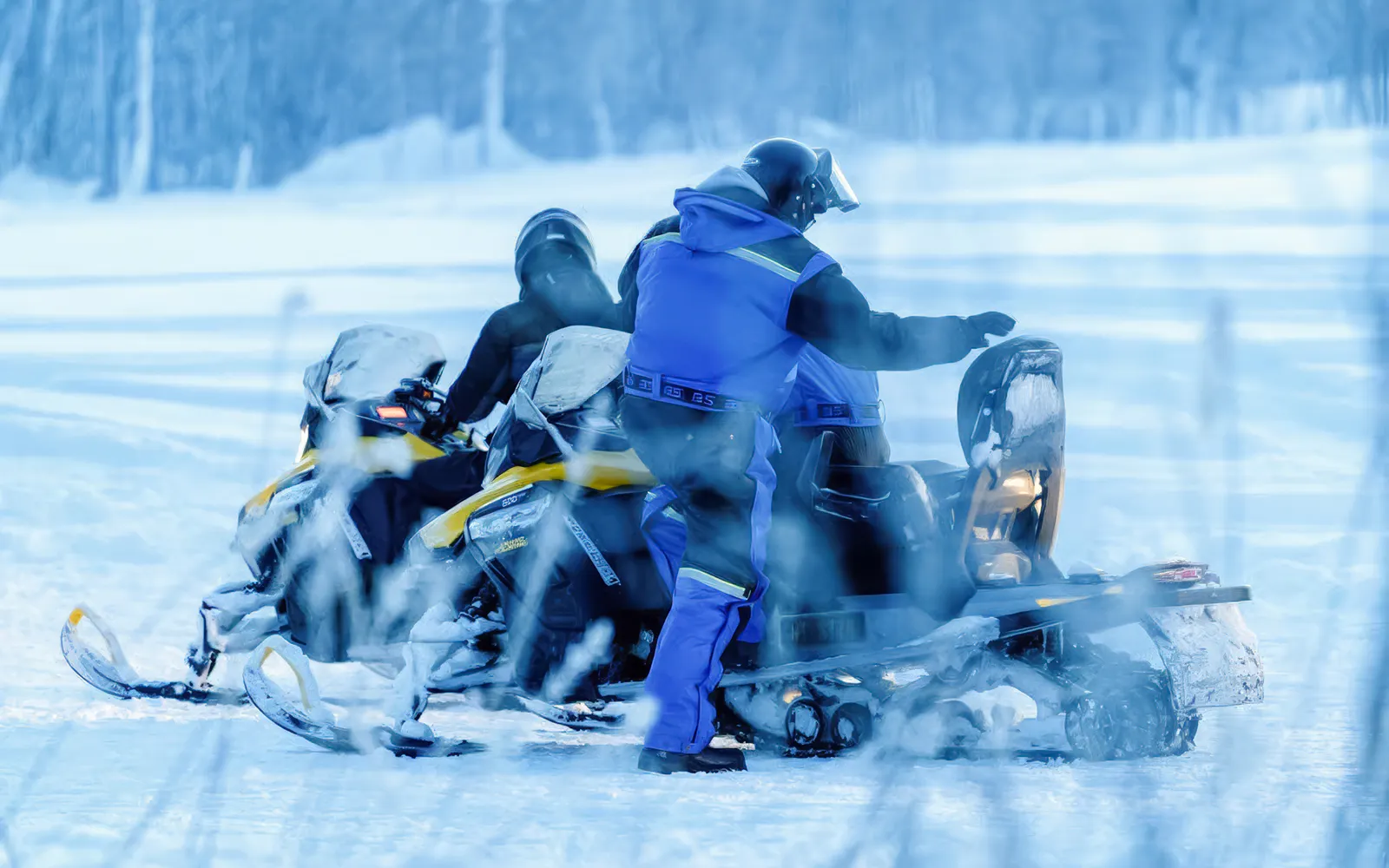 Snowmobilers on a snowy trail during a small-group day trip in Tromso.