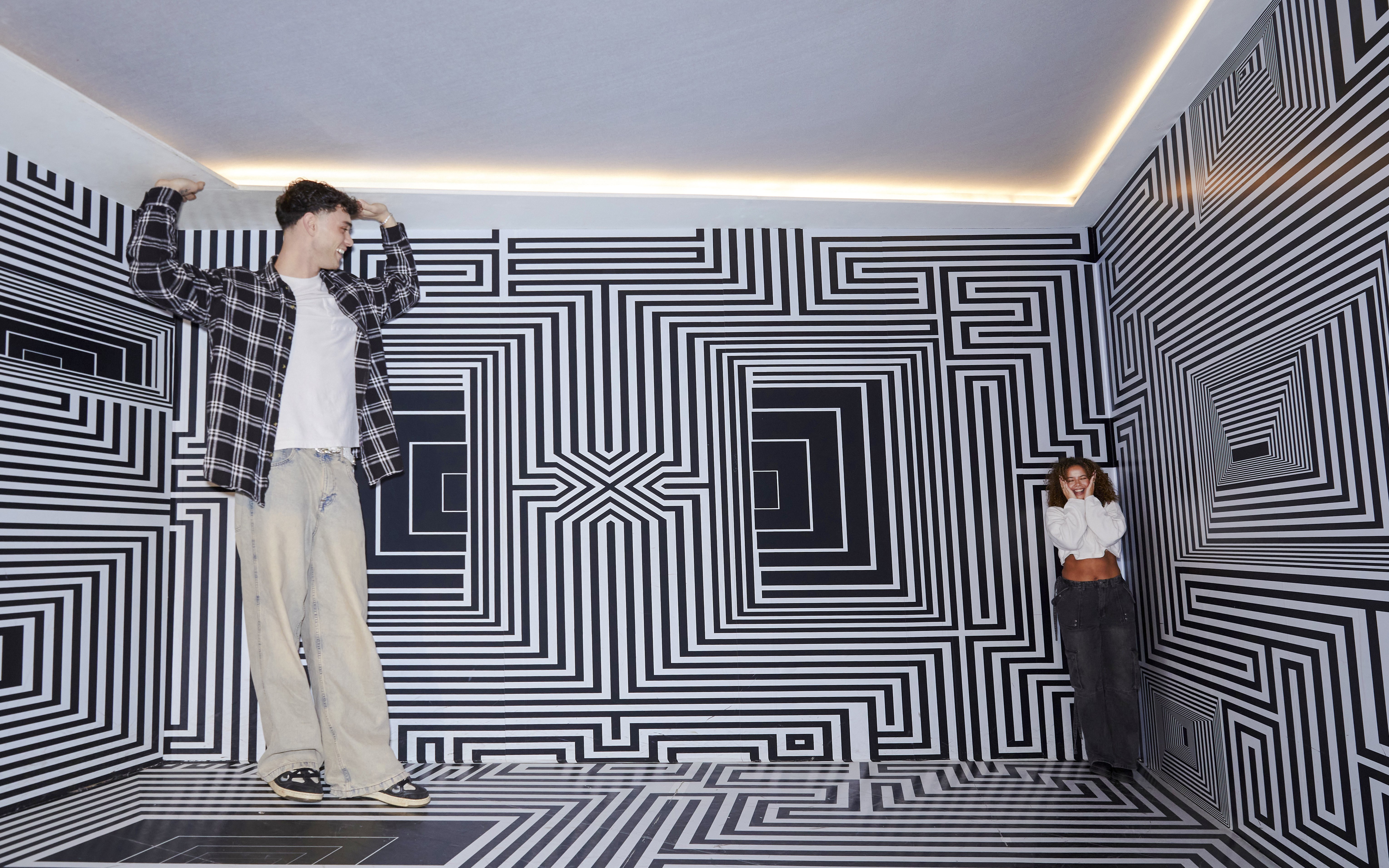 Guests exploring optical illusion room at Twist Museum, London.