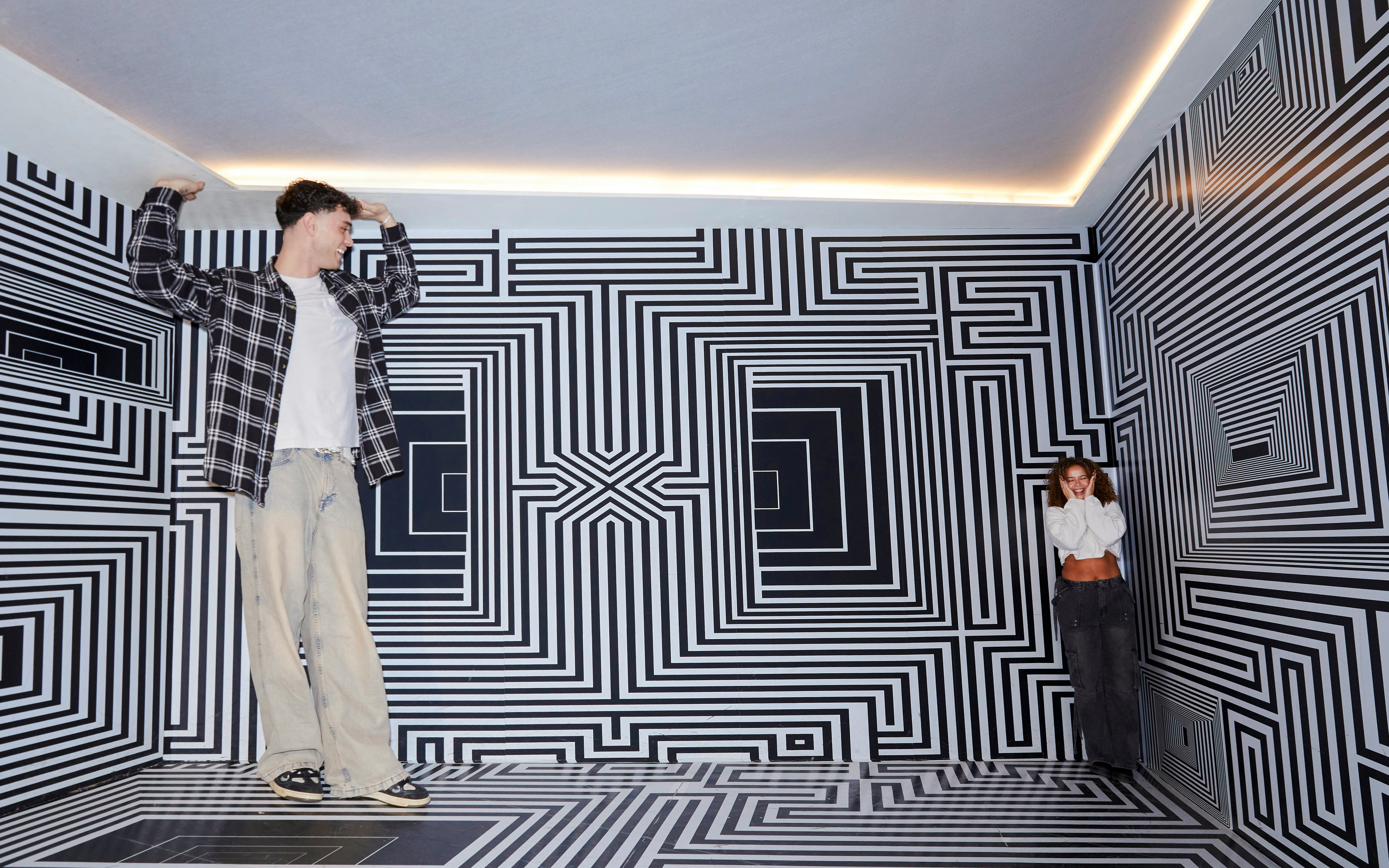 Guests exploring optical illusion room at Twist Museum, London.
