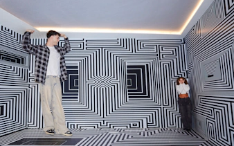 Guests exploring optical illusion room at Twist Museum, London.