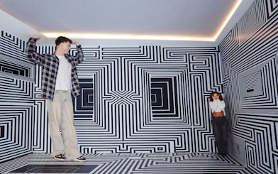 Guests exploring optical illusion room at Twist Museum, London.
