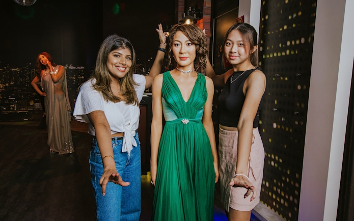 Wax figure of Michelle Yeoh with visitors at Madame Tussauds Singapore.