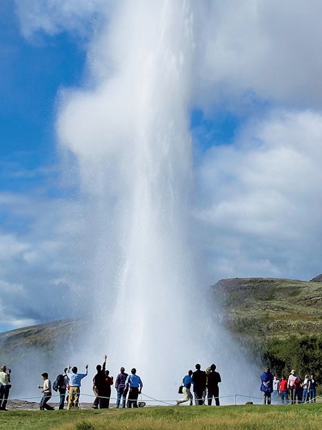 Tourists watching Geysir erupt during Golden Circle day trip in Iceland.