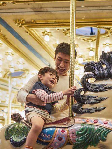 Father and child enjoying a carousel ride at Ocean Park.