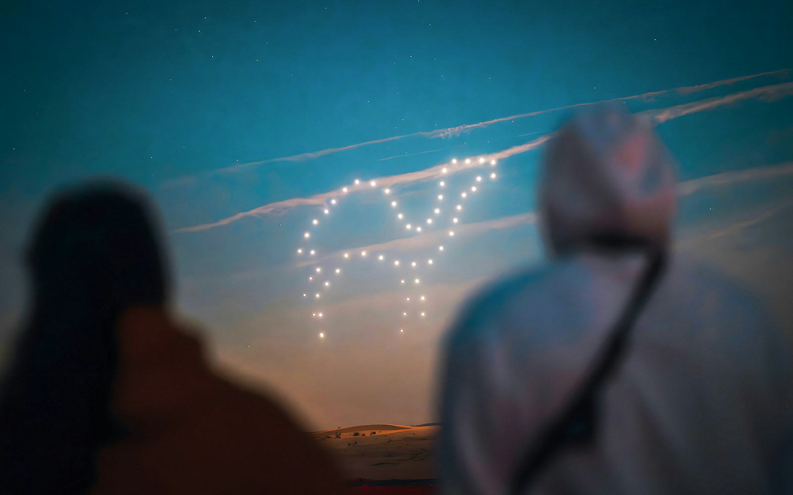 Drone light show forming a shape in the sky during a hot air balloon experience.