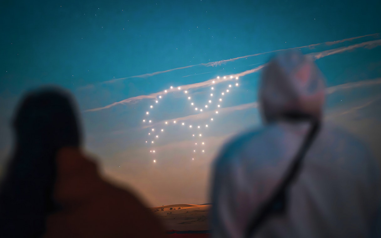 Drone light show forming a shape in the sky during a hot air balloon experience.