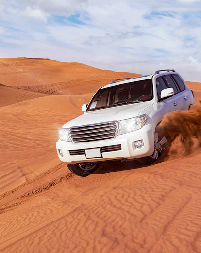 SUVs driving through sand dunes on a desert safari in Dubai.