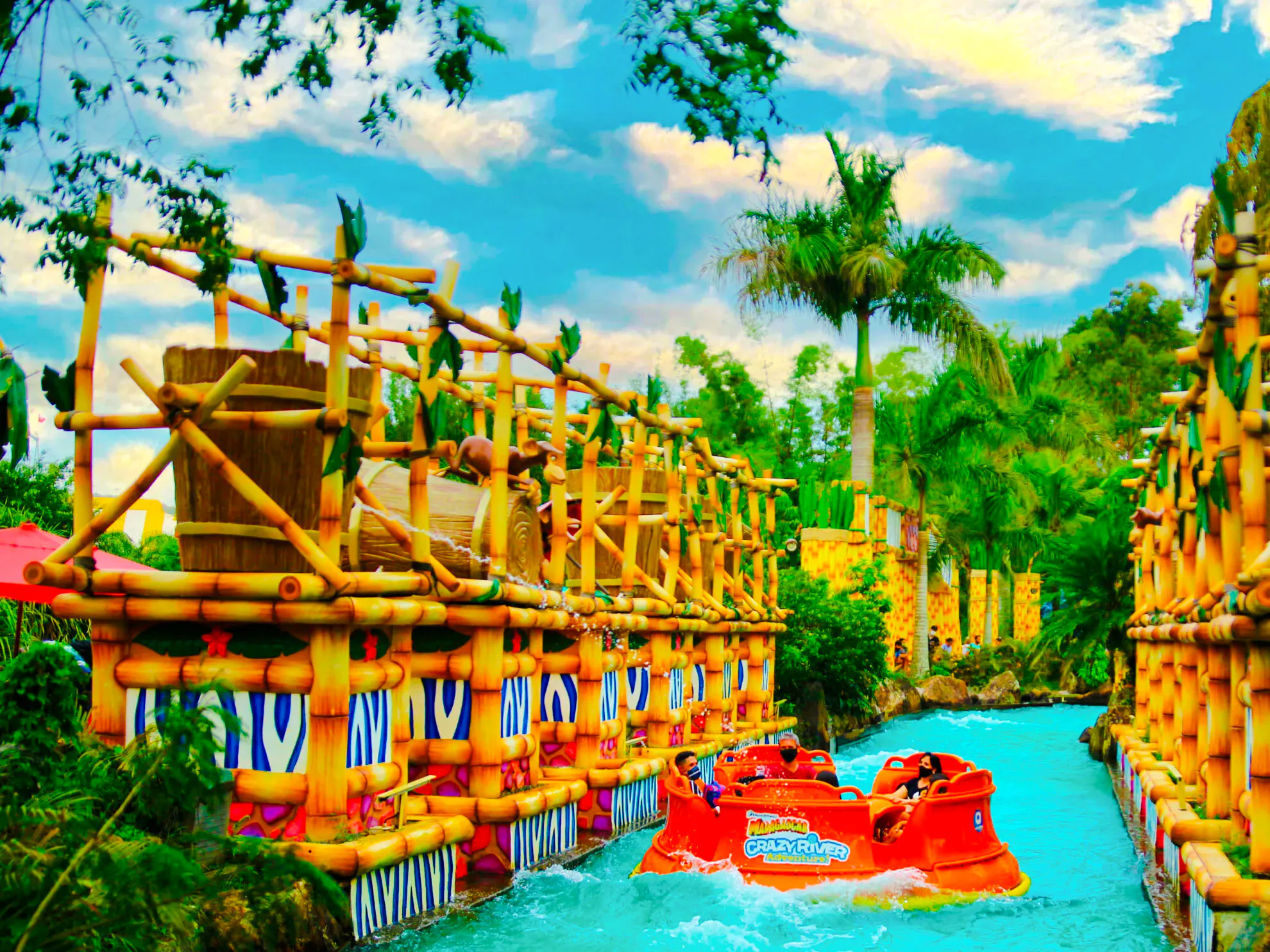 Raft ride at Beto Carrero World with bamboo structures and palm trees, Florianópolis transfer.