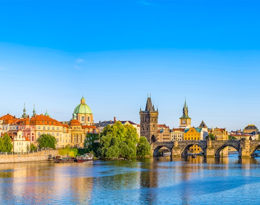 Prague skyline with Charles Bridge over Vltava River.