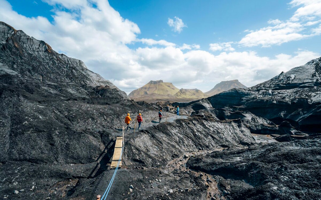 Guests walking on a path near Katla Ice Cave in Iceland.