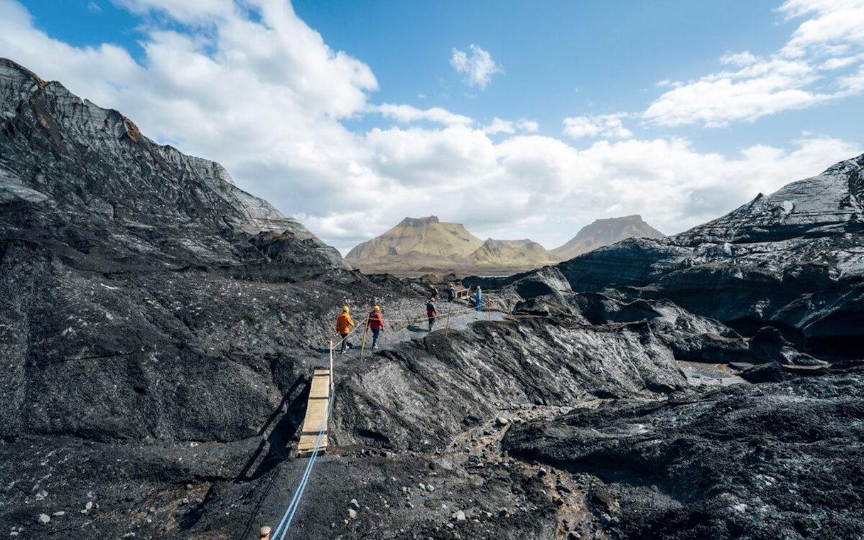 Guests walking on a path near Katla Ice Cave in Iceland.