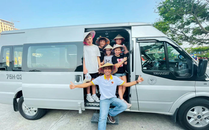 Tourists in a van for Hue to Da Nang trip with sightseeing via Hai Van Pass.