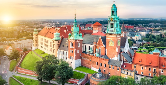 Wawel Castle on Wawel Hill in Krakow, Poland, with sunset in the background.