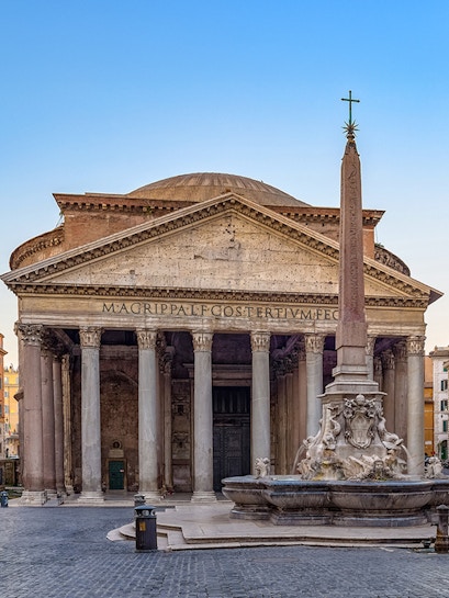 Pantheon in Rome with ancient columns and fountain in foreground.