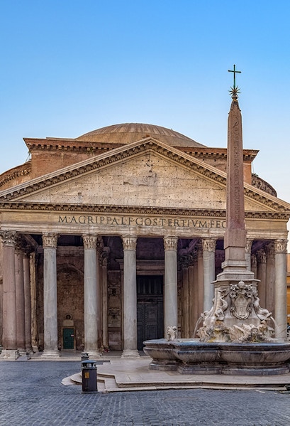 Pantheon in Rome with ancient columns and fountain in foreground.