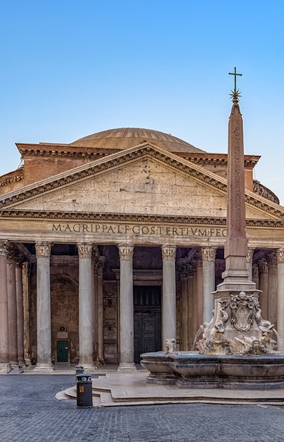 Pantheon in Rome with ancient columns and fountain in foreground.