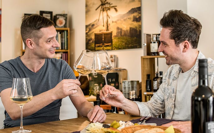 Guided wine tasting in a cozy wine bar with two people toasting glasses.