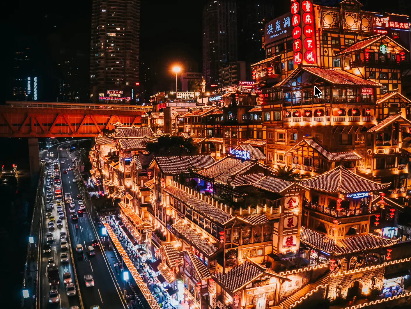 Chongqing night view with illuminated traditional buildings and busy street traffic.