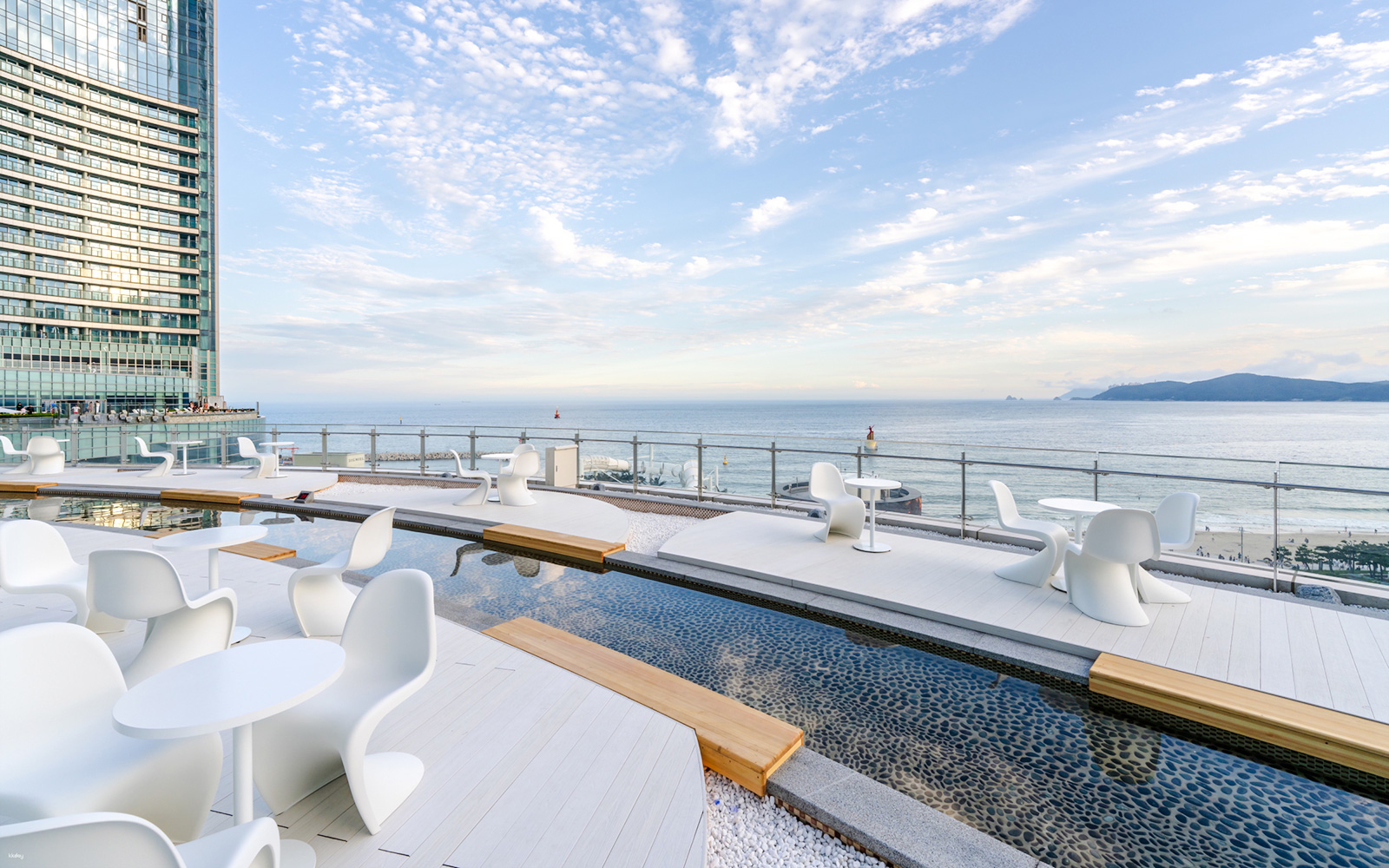 Outdoor terrace at Club D Oasis with modern seating and shallow water features by the sea.